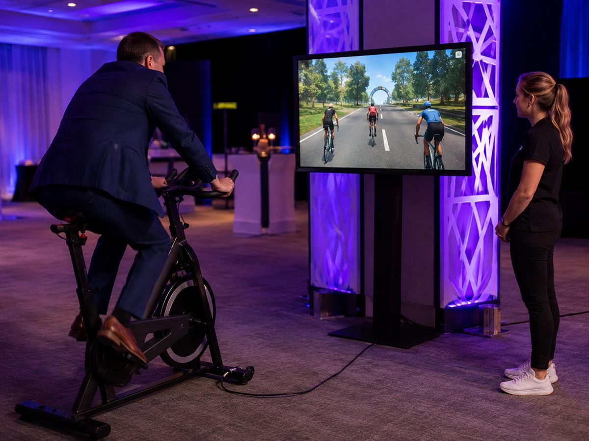 Guest pedalling a stationary cycle connected to an onscreen race